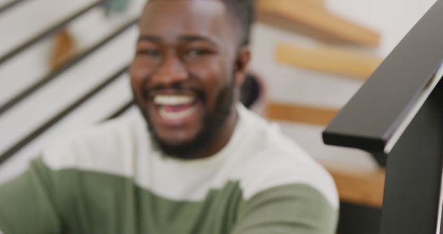 A cheerful African American man with a beard wearing a casual shirt, smiling with joy. Perfect for usage in advertisements, blogs, marketing materials, or websites promoting positivity, casual wear, the modern lifestyle, or concepts related to cheerful and happy living.