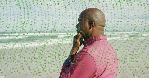 Senior man contemplating at shoreline touching chin wearing pink shirt green binary overlay