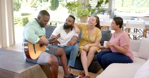 Group of Friends Enjoying Music Together on Couch