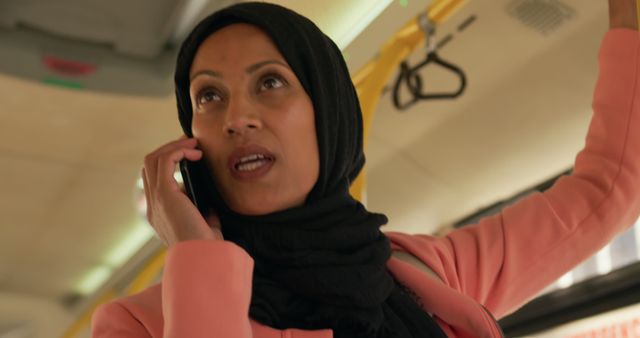 Confident Woman in Hijab Speaking on Mobile Phone in Public Transport - Download Free Stock Images Pikwizard.com