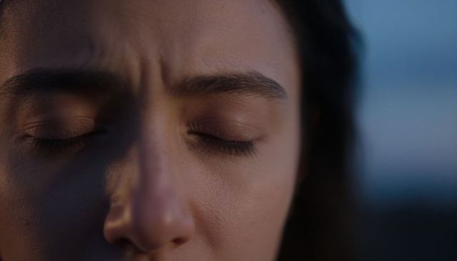Closeup woman resting with closed eyes at twilight, soft sidelight and natural skin texture