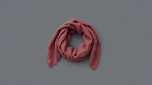 Elegant reddish-pink scarf on soft gray surface