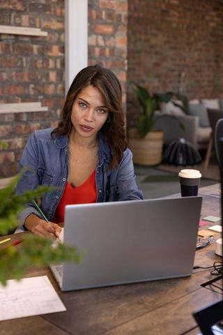 Young Woman Designing Blueprints in a Modern Studio Setting
