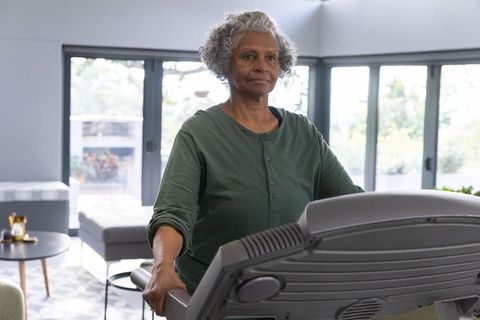 Senior African American Woman Exercising on Treadmill in Living Room