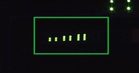 Green neon segment display showing vertical led bar readout on dark electronic panel