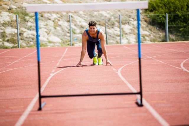 Athlete ready to jump a hurdle on running track