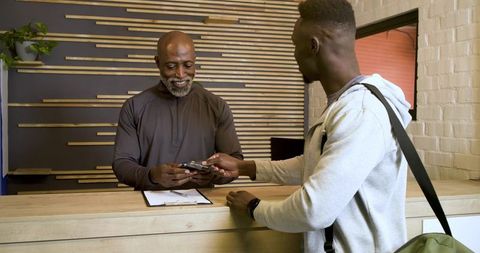 African american staff assists customer with payment at reception