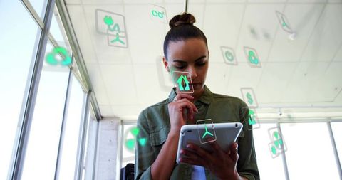 Businesswoman interacting with augmented reality tablet in bright modern office