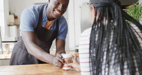 Friendly Barista Giving Coffee to Happy Customer at Cafe Counter