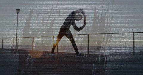 Silhouette man stretching on pier at sunrise with railing and lamppost, minimalist fitness