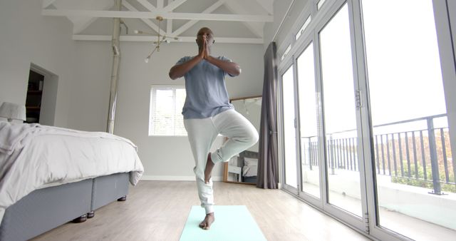 Man Practicing Yoga at Home Standing in Tree Pose on Yoga Mat - Download Free Stock Images Pikwizard.com