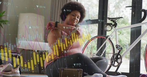 Checking smartwatch for cycling metrics while resting next to road bike at home