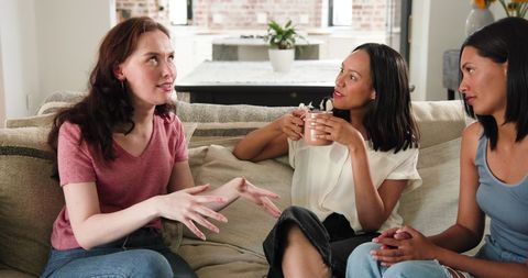 Female friends celebrating engagement in cozy living room