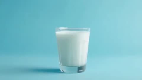 Glass of Milk on Teal Background with Minimalist Approach