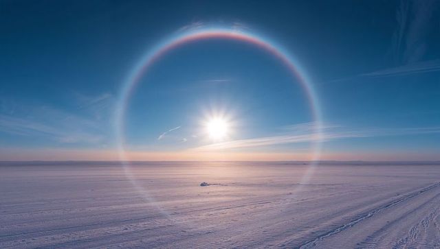 Sun halo ring over frozen plain framing low winter sun and arctic horizon