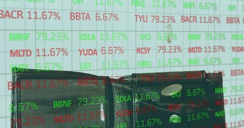 Dark leather wallet with metallic snap overlaid on stock market tickers for financial concept