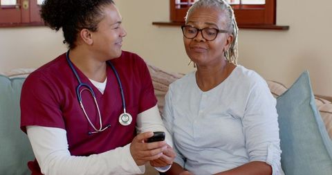 Nurse Showing Smartphone to Senior Woman for Telehealth Assistance
