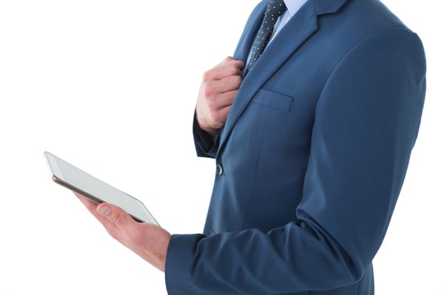 Businessman in a blue suit using a tablet computer. Ideal for illustrating concepts of modern business, technology in the workplace, corporate communication, and professional settings. Can be used in business presentations, corporate websites, and marketing materials.