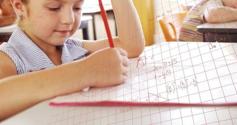 Child solving math on graph paper enhancing learning in classroom