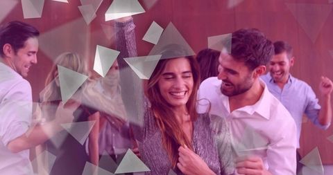 Couple dancing at warm indoor party woman in wide-brim hat celebrating with friends