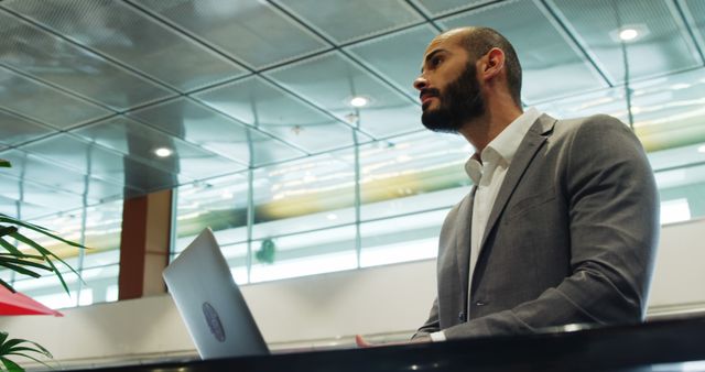 Confident Businessman Using Laptop in Modern Office - Download Free Stock Images Pikwizard.com