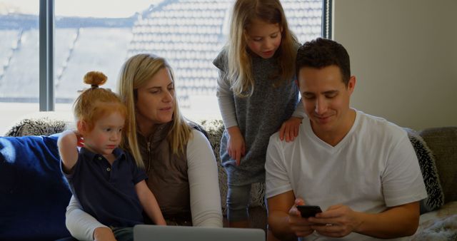 Family Relaxing on Couch Using Laptop and Smartphone in Cozy Home - Download Free Stock Images Pikwizard.com