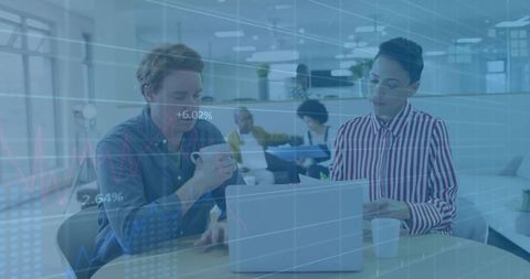 Collaborating over laptop and reports with financial data overlay in office coworking