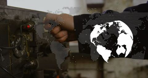 Technician turning control dial on industrial panel with global map overlay