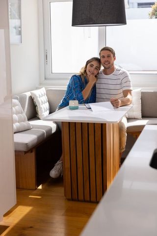 Couple Discussing Paperwork in Modern Kitchen Nook Cozy Atmosphere