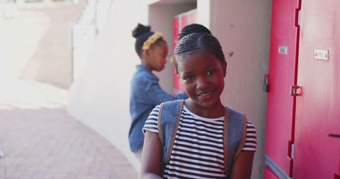 Smiling girl with backpack at school lockers