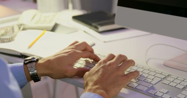 A middle-aged businessman types on a keyboard at a well-supplied office desk. - Download Free Stock Photos Pikwizard.com