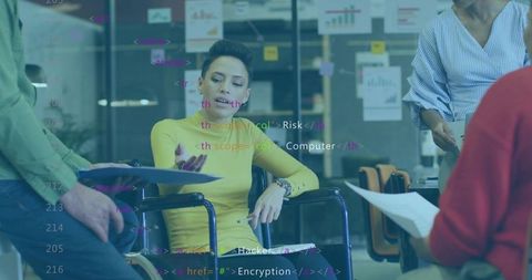 Discussing accessible teamwork with woman in wheelchair reviewing files and code overlay