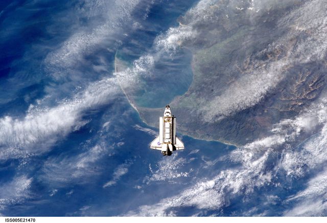 ISS005-E-21470 (25 November 2002) --- The Space Shuttle Endeavour is backdropped over the Tasman Sea and Golden Bay of New Zealand&#0146;s South Island as it approaches the International Space Station (ISS) during STS-113 rendezvous and docking operations. Docking occurred at 3:59 p.m. (CST) on November 25, 2002. The Port One (P1) truss, which was later to be attached to the station and outfitted during three spacewalks, can be seen in Endeavour&#0146;s cargo bay.