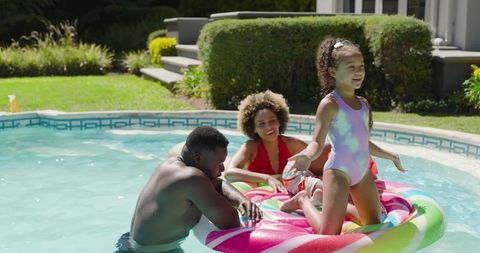 Diverse Family Enjoying Backyard Pool Fun on Giant Candy Float