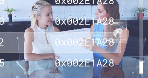 Businesswomen collaborating over spiral notebook with digital data overlay in glass office