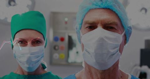 Senior surgeon leading surgical team in operating room with advanced monitors and lights