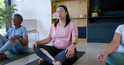 Multi-generational african american women practicing mindful meditation in sunlit living room