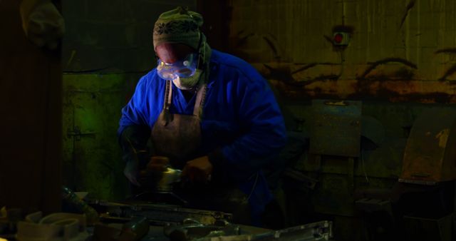 Industrial Worker Grinding Metal in Dim Workshop - Download Free Stock Images Pikwizard.com