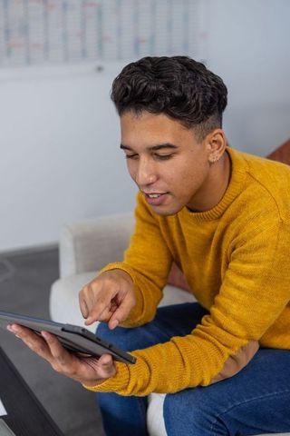 Casually Dressed Professional Using Tablet in Modern Office