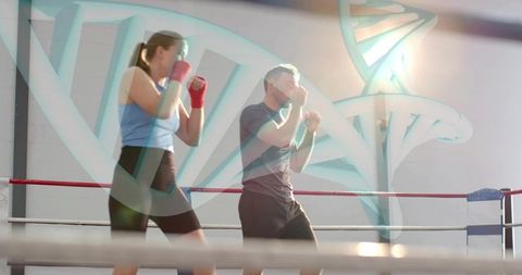 Boxing partners sparring with dna helix overlay representing genetic fitness and training