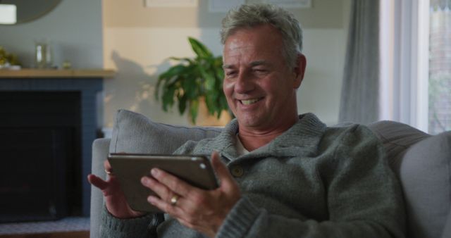 Smiling Senior Man Using Tablet on Living Room Sofa - Download Free Stock Images Pikwizard.com