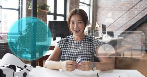 Asian businesswoman in tech-driven workspace with digital maps