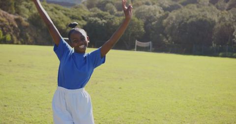 Joyful african american girl celebrating victory on a sunny day