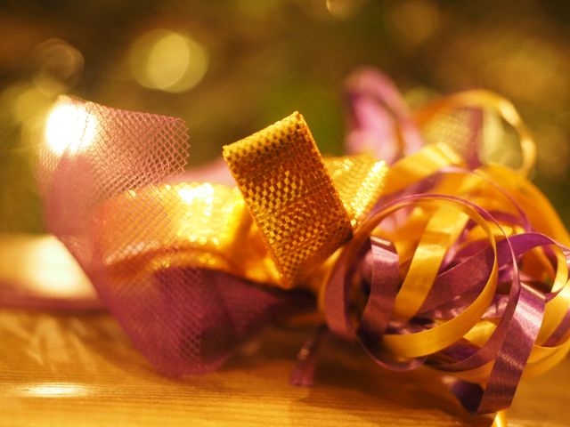 Close-up view of colorful tangled ribbon with golden and purple hues. Perfect for festive holiday decorations, gift wrapping themes, or celebratory designs. This could be used in stock imagery for party planning, holiday greetings, or background design elements.