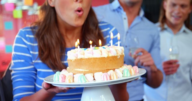 Woman Blowing Out Candles on Birthday Cake Celebrating with Friends - Download Free Stock Images Pikwizard.com