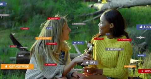 Friends clinking beer bottles in meadow with social media notifications and likes overlay