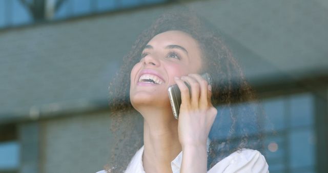 Smiling Young Professional Woman Speaking On Mobile Phone Through Window - Download Free Stock Images Pikwizard.com