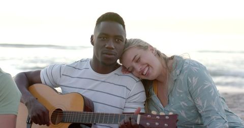Couple Enjoying Beach Music with Guitar