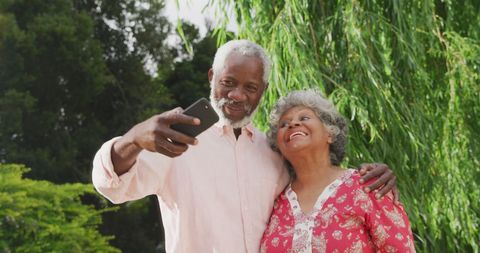 Happy Senior African American Couple Taking Selfie in Park