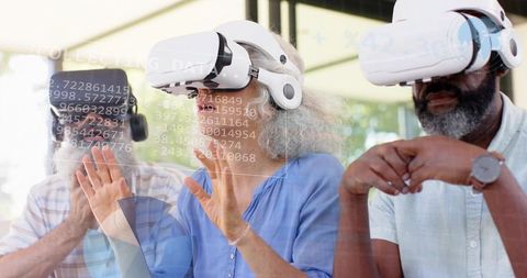Mature adults exploring virtual reality workshop with white vr headsets and projected data